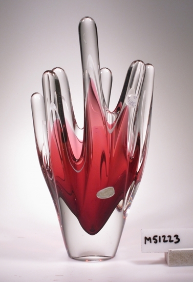 Vas.
Beskrivning: Skulptur (vas) med åtta fingrar som sträcker sig uppåt.
Färg: Klarglas, rosa och vit.
Teknik: Coquille - rött underfång med vit tråd i överkant, slungad, 
planslipad i botten.
Mått: Ovan angivna diameter avser största mått.
Märkning: Guldetikett "Ekeberga Sweden".
Inskrivet i huvudkatalogen 2007.

Inköpt av glasantikvarie Gunnel Holmer 2007-10-21.
Funktion: Prydnadsvas