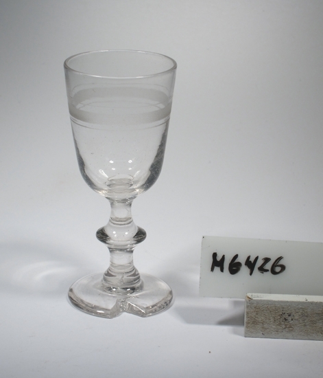 Vinglas, berliner.
Beskrivning: Matt rand. Ben med skarp knapp.
Färg: Ofärgat klarglas.
Mått: Ovan anges övre diameter. Fotdiameter: 43 mm.
Inskrivet i huvudkatalogen 1934.
Funktion: Vinglas