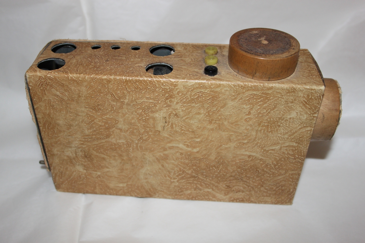 Radiomottaker, hjemmelaget. Rektangulært chassi laget i trefiner.. Med sorte høretelefoner med stempel OMEGA. Dette eksemplaret er fortsatt i utmerket stand. Det følger også med en improvisert antenne.