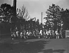 Barn med flaggor vid Gammelstilla bruk, Torsåker, före 1915.