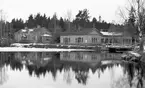 Dammen vid Stallbacken i Hofors omkring 1920. Huset till vänster byggdes omkring 1890 där fick rasänkorna bostad efter det att taket rasat in i verket, vintern 1895. Sedan blev det bostäder och telegraf. Slaggstensbyggnaden till höger. Gjuteri sedan en mekanisk verkstad och plåtslager. På 1920-talet mejeri.