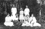 Personerna är från vänster: Anna Eriksson, Lenninge 6:42, född 1900, Tilda Eriksson, Lenninge 6:42, född 1903, tre okända personer, sittande till höger Karin Larsson, Lenninge 5:29, född 1901 och Lisa Eriksson, Lenninge 6:42, född 1901.