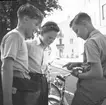 Ferieskolan börjar. Ungdomar utanför läroverket. Den 17 juli 1950