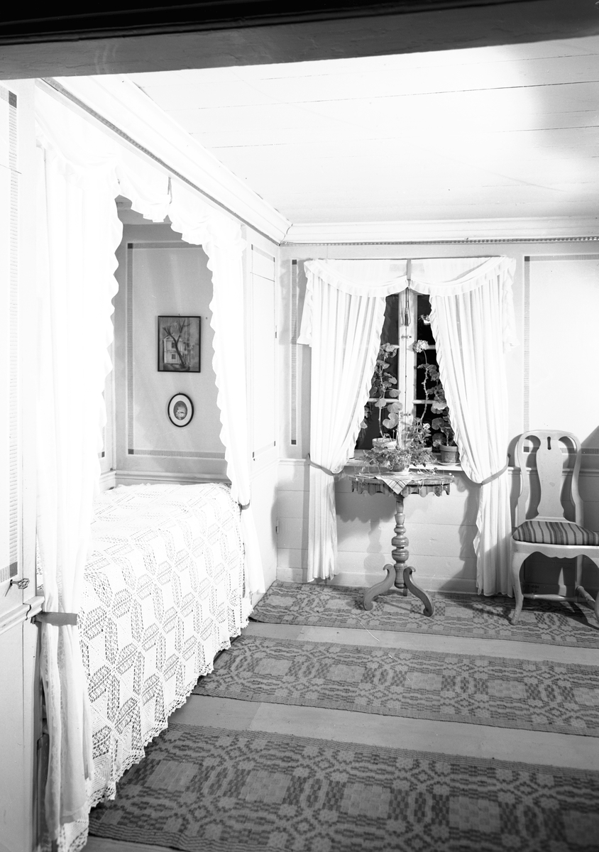 Kammaren med sängalkov och möbler i bondrokoko. Hemvävda mattor av fru Maria (Brita) Östlund. Från boken "Svenska Hem i ord och bilder".
