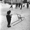 Skridskoåkning på Kristinaplan, Gävle, 1957. Ett barn med sparkkälke.