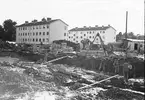 Husbygge, augusti 1944.
Det närmaste huset har adressen Brändströmsgatan 18 och huset till höger är nr 16.
Kvarteret heter Bispen enligt 1950 års karta.
Brändströmsgatan går tvärs över bilden längs husens närmaste gavlar. 
Närmast fotografen, som blickar söderut, syns resultatet av grundgrävningen för Engelbrektsgatan 13 och 15.
Närmast till vänster utanför bilden ligger ett likadant hus till, Brändströmsgatan 20, som även har adressen Engelbrektsgatan 11, och som har Borgarskolans gymnastikhus som granne tvärs över Engelbrektsgatan.