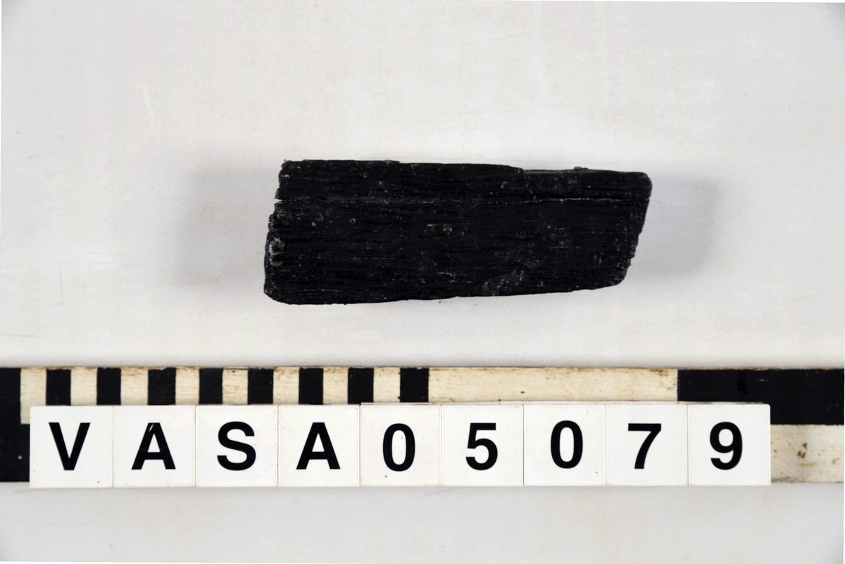 Dekorativt romboidformad ornament med elongerad pyramidformad dekoration. Platt topp. Konvex baksida. Konstant tjocklek oavsett baksidans vinkel. Kraftigt vittrade ytor, hörn, och sidor.