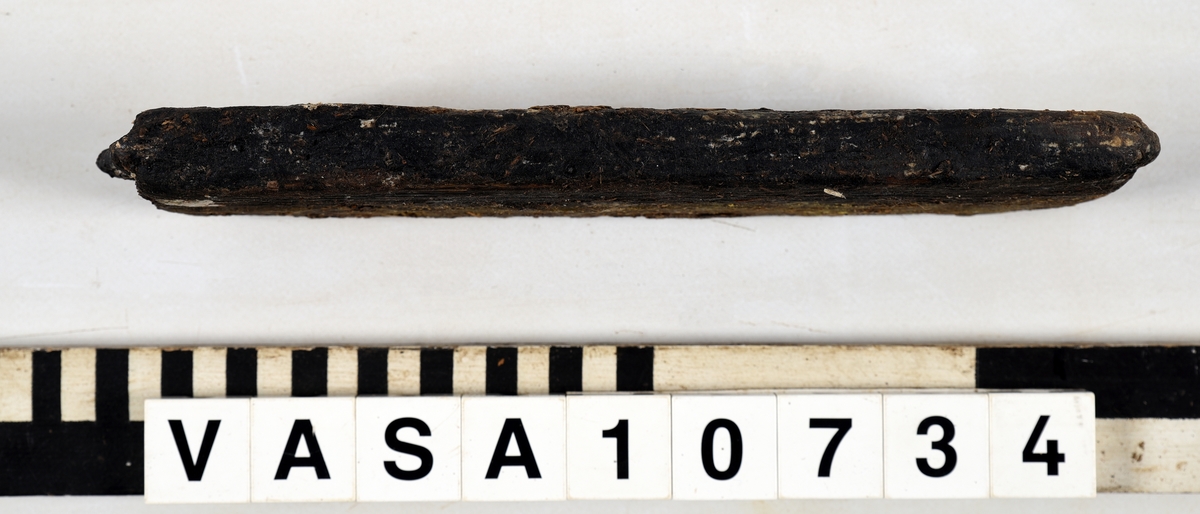 Odekorerad rektangulär bräda med ett spikhål. Tapp på båda ändarna möjlig spont på långsidan. Mycket vittrad yta. Kraftig saltskada (Salt 4) Tapparna avsplittrade.