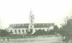 Borgholms kyrka, kring sekelskiftet 1900. Kyrkan är delvis skymd av buskar.