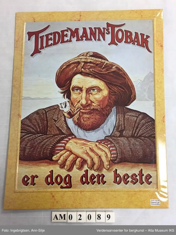 Form: Rektangulært reklameskilt i stående format. Motivet er den fornøyde "Tiedemannsgubben" med pipe og sydvest. I bakgrunnen er det hav og fjell. Skriften på skiltet er skrevet over hodet og under armene til "gubben".  Rundt motivet er det en gul kant som rammer inn.