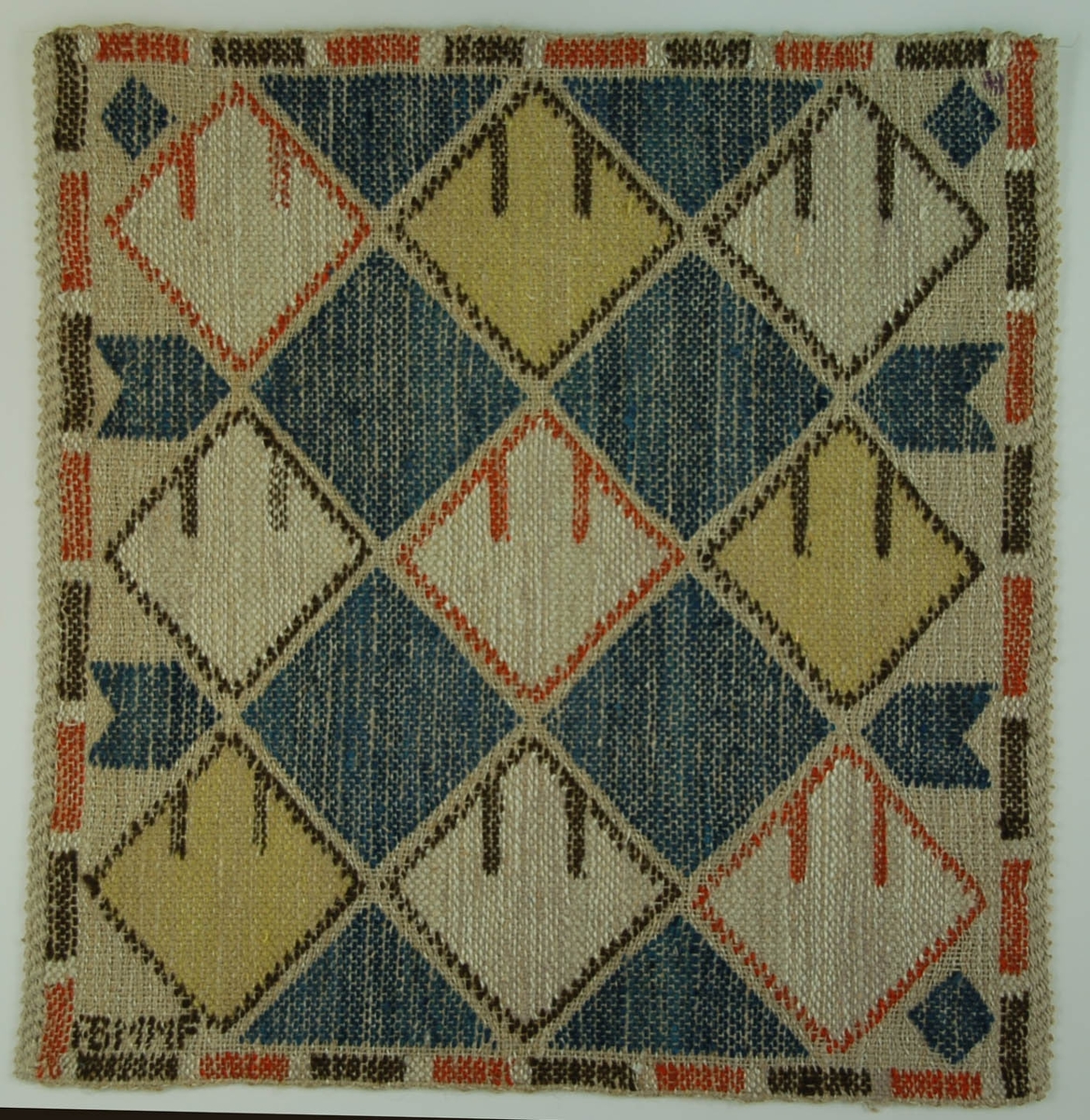 Vävnad, flossaväv, "Linneknoppen". 1930-tal. Varp av grått halvblekt lingarn. Inslag av brungrått lingarn och inplockat i  mönster gult, rött, blått och brunt ullgarn. 
Hellen Schmidt Landgren.

Längd: 40,5 cm          Bredd: 40 cm
Varp: 5 tr/cm            Inslag: ca 6/cm
Varp ljusgrått, oblekt lingarn, inslag vitt, gulgrått och ljusgrått, oblekt lingarn svart, rött, rödbrunt, blått, mörkblått och gult ullgarn, troligen 1 tr, inplock på linnebotten, MMF-teknik. Geometriskt mönster av romber, vid sidorna viggformer, vid kanterna trekanter, runtom en fyrkantig bård av rektangulära fält.

Vävnaden avslutas med s.k. orientalisk fläta.

Vid nederkantens ena hörn invävd signatur AB MMF i svart ullgarn.

Kanal fastsydd på avigsidan längs övrekanten.