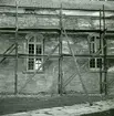 Böda kyrka under restaureringen 1942. Parti av långhusets norra vägg med korsarmens nordfasad. Under den nedknackade putsen syns det medeltida murverket med en igensatt portal.