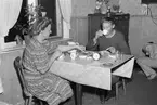 Man och kvinna vid köksbord. Reportage från Bönan. År 1948. Reportage för Afton-Tidningen. Beställt av fru Wesslén, Bönan.