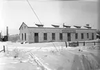 Exteriör av fabriksbyggnaden, 6 april 1946. År 1931 inköpte O. M. Grudén av Åbyfors bruk en fabriksbyggnad, där han efter omfattande restaurerings- och moderniserings arbeten  var fabriken klar för att börja användas.  Ingenjör O. M. Grudén grundade fabriken belägen i Åby, Valbo tillverkning av snökedjor. . Kedjorna tillverkas i alla förekommande storlekar och för alla hjuldimensioner för såväl person-som lastautomobiler samt för motorcyklar och traktorer. Sammansättningen av länkarna och kedjorna sker för hand. Omnämnas bör att en man sammansätter 100 kedjor på en dag.