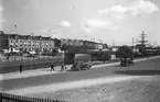 Torghandel på Fisktorget, Briggen Gärdas master syns och en spårvagn svänger upp på Svängbron