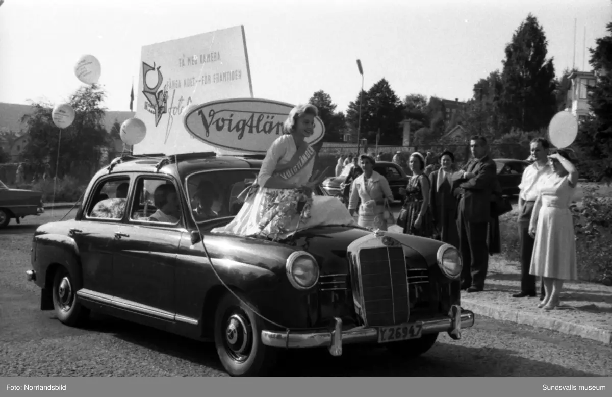 Köpmännens dag i Sundsvall. Paradsmyckade bilar och lastbilar från exempelvis Béves, Bengt Hagman Livsmedel, Lindgrens järn och Engelfeldts möbler.