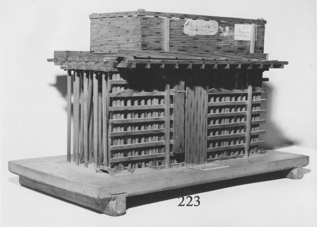 Två modeller av trä utvisande pålningen under vattnet för uppförandet av Inventariekammaren No 1. Byggnaden uppfördes åren 1781-84 efter ritningar av J. E. Nordberg. Under arbetets gång lär dessa ha ändrats av generalamiralen Ehrenswärd och överskeppsbyggmästaren Henrik af Chapman.