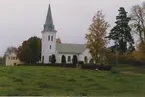 Dalhems kyrka med en åker i förgrunden. Foto från renoveringen 1993.