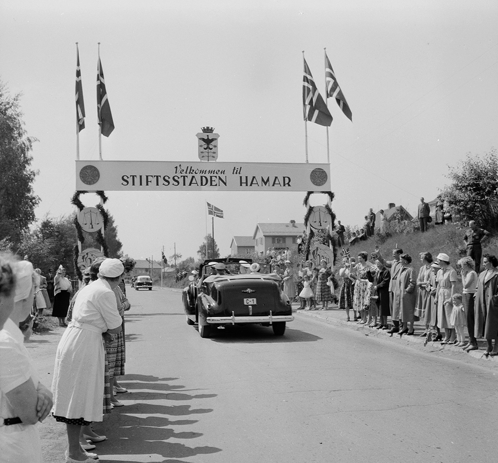 Hamar, Vangsvegen, Disen, Signingsreisen 1958 kong Olav og prinsesse Astrid, bilkortesje, portal, girlander "Velkommen til Stiftsstaden Hamar",  Tilskuere norske flagg. Kongebesøk, kongebil Buick C-1,