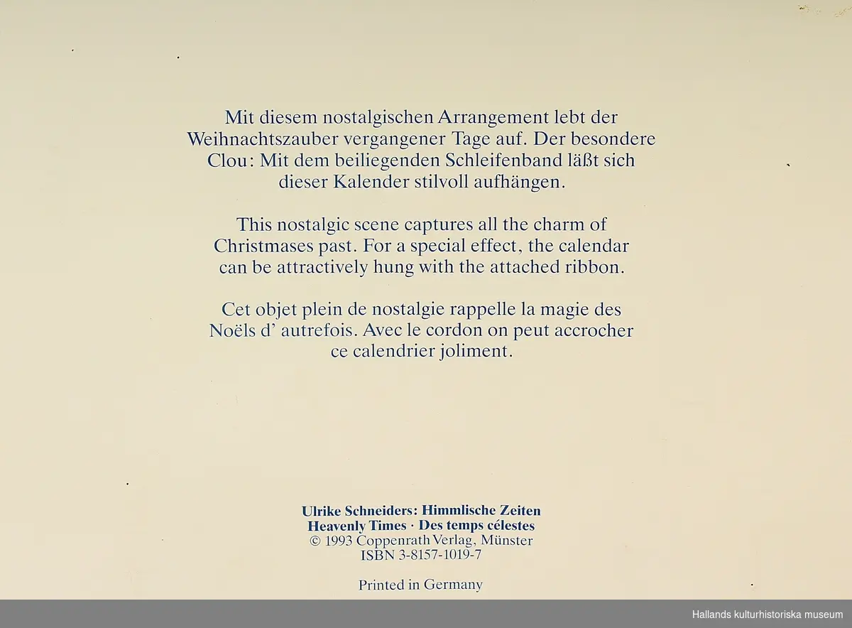 Julkalender av papper. Motiv med änglar, dekorerad med glitter. Mörkrött upphängningsband med guldtryck.
Text baksida: "Ulrike Schneiders: Himmlische Zeiten...", "Printed in  Germany".