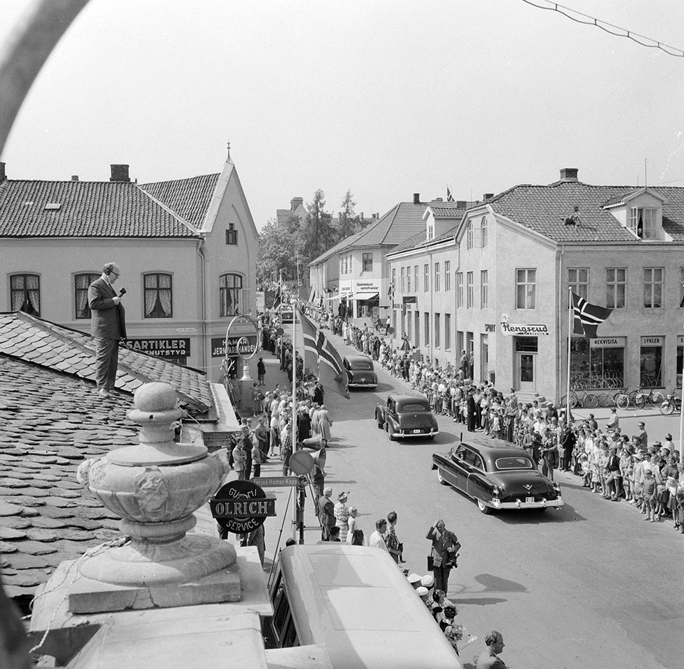 Hamar, Storhamargata, Signingsreisen 16.06.1958, Kong Olav V og prinsesse Astrid, Strandgata, kjører i åpen bil, bilkortesje, tilskuere, presse, nedre Aasgården, Flengsrud sport, Hamar, bakerste bil kongens  C-2, journalist - reporter med mikrofon på taket av Basarbygningen, Flengsrud Sport i Storhamargata 11,