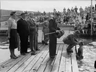 Överstelöjtnant Hjalmar Ekstedt placerar magisterkransen på en ung promovenda, Fyrisbadet, Svartbäcken