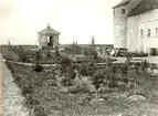 Det lilla lusthuset som förr fanns på Kalmar slott, öster om Kuretornet på yttre vallen. Grimskär i bakgrunden ger orientering. Fotot är taget 1880-1886 och visar landshövdingen med familj.