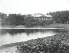 Huvudbyggnaden på Falsterbo bruk med Brukssjön i förgrunden.