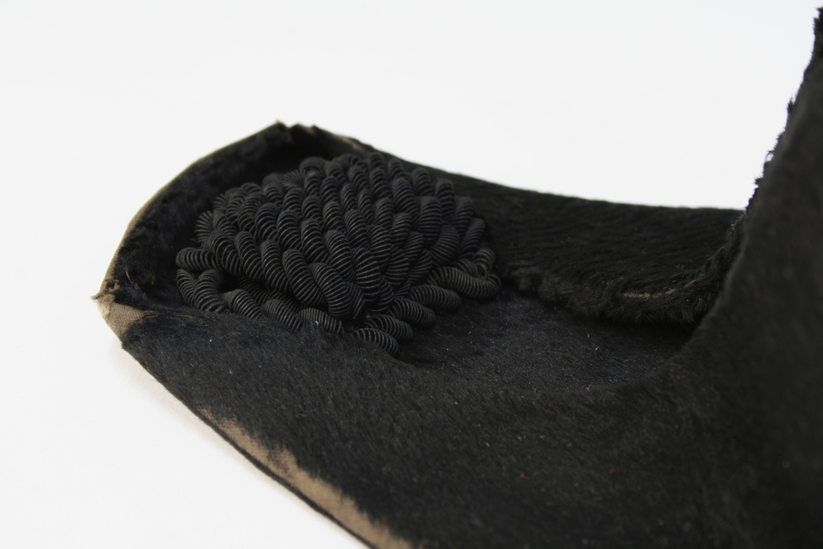 Hatten har nasjonalkokarde, krampe og besetning av possementsarbeid i gull.