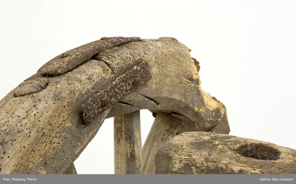 KLM 11833. Bultvagn, hästvagn. Av trä och järn. För hästar. Bultvagn som består av två hjulpar med två bankar, fyra träaxlahjul med järnbeslag, skakel samt dräkt. Det främre hjulparet är mindre än det bakre och har en tillhörande skakel som fästes i en träanordning på dess bank. Dräkten består av en kraftig rektangulär stång av trä med sex stycken borrade hål. Dräkten fästes i en annan träanordning som sitter på motsatt sida av skakeln på det främre hjulparets bank. På det bakre hjulparets bank sitter ett bågformat hål där dräkten sedan förs igenom för att sammankoppla vagnens delar samt justera dess längd. De bakre hjulens nav är dekorerade med zig-zag mönster.