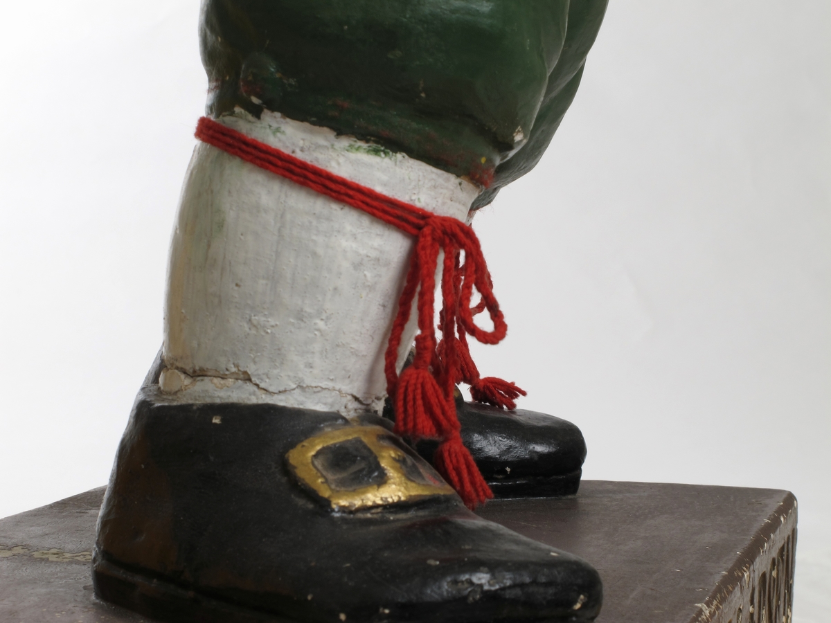 Julenisse med sjokoladeplate på venstre arm.