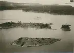 Flygfoto över ön Skansholmen vid farleden in till Västervik. Huset på ön är klubbhus för WSS (Westerviks SegelSällskap). Klubbhuset byggdes 1916 efter ritningar av arkitekt Axel J Sjögren.