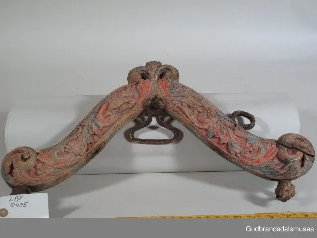 "A 100-161. 62 selatre og høvrel. Arbeid av Klukkstad, Skjaak-Ola, Sev. Gjerstad, Sylfest Skrinde osv. Alle fraa Lom og Skjaak. 30 selatre + 32 høvrel. NB. Desse tre er meste alle av dei eldste typur i Gudr.dalen; some skriv utan tvil fraa fyre reformasjonen". (jf. Katalog for Lom bygdesamling, 1925).
Høvre av bjørk, selvvokst emne med utskåret krone. 1 tømmering mangler, 1 tømmering av jern med 5 cm. lang hals ført gjennom treet til høvreundersiden. Herfra har feste for seleball (selepute) tidligere fortsatt i forlenging av halsen. Fester for seleballer har seinere blitt avfilt i nivå med høvreundersiden. Høvren har ingen hull for annen type seleballfeste. Jernfeste for ryggreim, midt på fremsiden, festet til øyeformet krok slik den er bevegelig. U-formet krok/hempe midt på baksiden, bruk uviss, har muligvis vært brukt til bjelleoppheng. Fester av jern med dekor for oppholdsreimer.
DEKOR. Utskåret krone, skåret akantusmotiv og profilerte kanter malt i blått, oransje opp på skurddekor og rød som bunnfarge. Eldste/underste malingslag på skurddekoren ser ut til å ha vært oransje, yngste blått. Smijernsdekor, små rosetter med 6 blader, på fester for oppholdsreimer. Høvret har en fyldig akantus som man kan se det i akantusskurden i perioden 1750-1800, rokokkoinspirerte stengelstubber med bladtunger og bladformer uten stengel. Den liljeformede krone på høvret er et stilelement som Ola Iverson Bræk, 1749-1833, ofte brukte på skapene sine. Malingsbruken med sterkere rød/oransje og blå farge tilhører det tidlige 1800-tallet. 
BRUK. Høvre og bogtre hører sammen. De utgjør de primære festeanordningene for seletøyet og medvirker til å fordele trekkbelastningen på en hensiktsmessig måte. Høvren er plassert fremme over ryggen på hesten. Den har huller eller ringer som tømmene blir ført igjennom og er i tillegg festepunkt for rygg- og bære-/oppholdsreimer. Bærereimene går videre nedover og er koplet til draget/skåken.
Bogtrærne er festet til hverandre over nakken med en nakkereim og rundt brystet med en brystreim. Midt på treet er det hull for feste av dråtten. Dråtten, en 6-7 cm. bred, stiv lærreim, blir i motsatt ende festet til draget/skåken.