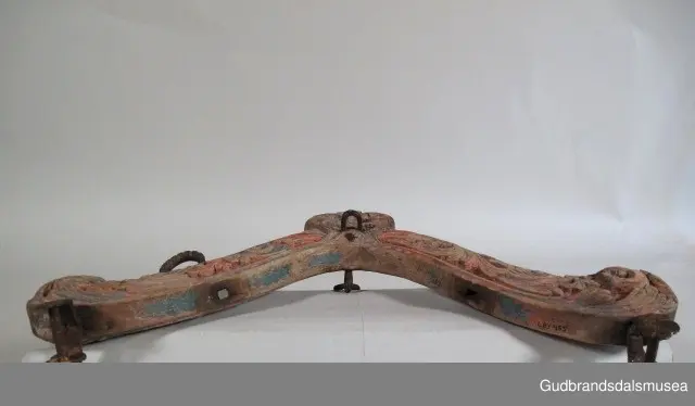 "A 100-161. 62 selatre og høvrel. Arbeid av Klukkstad, Skjaak-Ola, Sev. Gjerstad, Sylfest Skrinde osv. Alle fraa Lom og Skjaak. 30 selatre + 32 høvrel. NB. Desse tre er meste alle av dei eldste typur i Gudr.dalen; some skriv utan tvil fraa fyre reformasjonen". (jf. Katalog for Lom bygdesamling, 1925).
Høvre av bjørk, selvvokst emne med utskåret krone. 1 tømmering mangler, 1 tømmering av jern med 5 cm. lang hals ført gjennom treet til høvreundersiden. Herfra har feste for seleball (selepute) tidligere fortsatt i forlenging av halsen. Fester for seleballer har seinere blitt avfilt i nivå med høvreundersiden. Høvren har ingen hull for annen type seleballfeste. Jernfeste for ryggreim, midt på fremsiden, festet til øyeformet krok slik den er bevegelig. U-formet krok/hempe midt på baksiden, bruk uviss, har muligvis vært brukt til bjelleoppheng. Fester av jern med dekor for oppholdsreimer.
DEKOR. Utskåret krone, skåret akantusmotiv og profilerte kanter malt i blått, oransje opp på skurddekor og rød som bunnfarge. Eldste/underste malingslag på skurddekoren ser ut til å ha vært oransje, yngste blått. Smijernsdekor, små rosetter med 6 blader, på fester for oppholdsreimer. Høvret har en fyldig akantus som man kan se det i akantusskurden i perioden 1750-1800, rokokkoinspirerte stengelstubber med bladtunger og bladformer uten stengel. Den liljeformede krone på høvret er et stilelement som Ola Iverson Bræk, 1749-1833, ofte brukte på skapene sine. Malingsbruken med sterkere rød/oransje og blå farge tilhører det tidlige 1800-tallet. 
BRUK. Høvre og bogtre hører sammen. De utgjør de primære festeanordningene for seletøyet og medvirker til å fordele trekkbelastningen på en hensiktsmessig måte. Høvren er plassert fremme over ryggen på hesten. Den har huller eller ringer som tømmene blir ført igjennom og er i tillegg festepunkt for rygg- og bære-/oppholdsreimer. Bærereimene går videre nedover og er koplet til draget/skåken.
Bogtrærne er festet til hverandre over nakken med en nakkereim og rundt brystet med en brystreim. Midt på treet er det hull for feste av dråtten. Dråtten, en 6-7 cm. bred, stiv lærreim, blir i motsatt ende festet til draget/skåken.