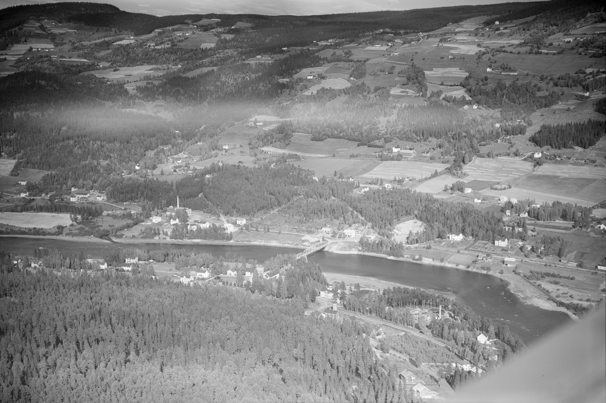 Tretten, Øyer, 1952, Lågen, Tretten bru, jordbruk, gårder, bolighus, blandingsskog. Bildet tatt fra vestsiden. Jernbanesporet vises i nedre billedkant, med vanntårnet og Losnaos Hotell bak. Kaseinfabrikken helt nederst til høyre.