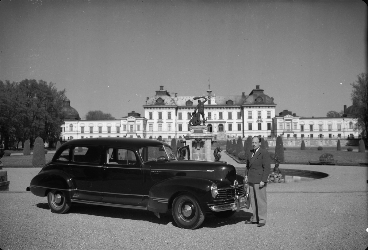 Bil av märket Hudson av årsmodell 1946-47, förlängd till 7-sitsig. Avbildad framför Drottningholms slott. På bilden syns även skulpturen Herkules kamp med draken av Adriæn de Vries, utförd i Prag 1590 - 1593.
