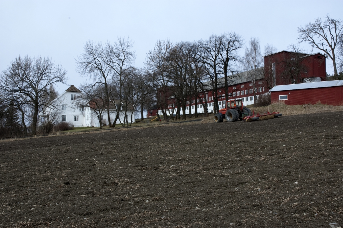 Hovelsrud, Helgøya, Ringsaker. Hovedbygning, låve og vognskjul. Traktor med trommel. Fotografert for Ringsakboka VI, utgitt 2006.