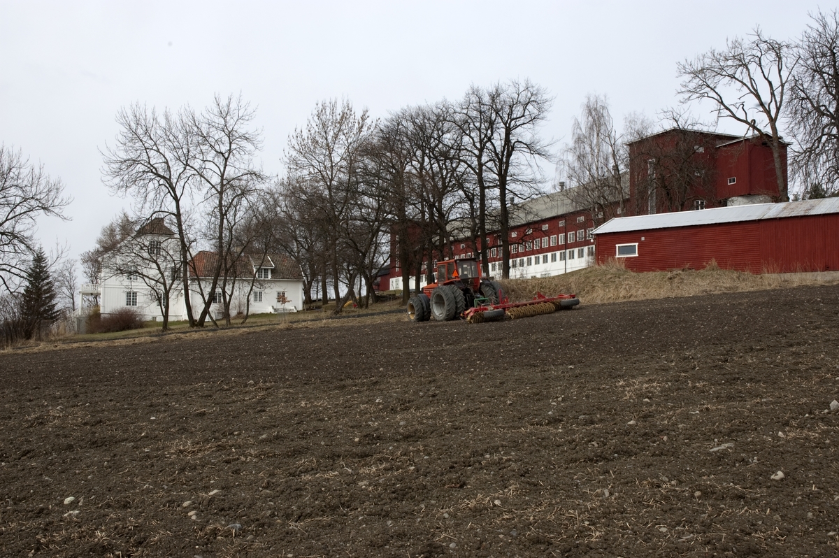 Hovelsrud, Helgøya, Ringsaker. Hovedbygning og låve. Traktor med trommel. Fotografert for Ringsakboka VI, utgitt 2006.