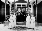 En brudpar, ståendes på en trappveranda.