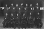 Grupporträtt. Värnpliktiga, uniformerade män vid F 6 Västgöta flygflottilj står uppställda vid en hangardörr, 1940-tal.