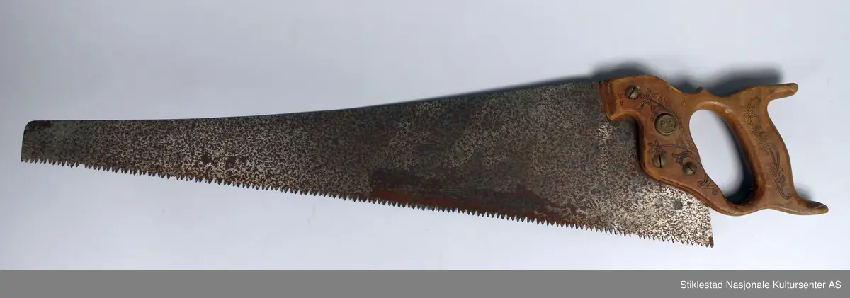 Håndsag med dekorert treskaft med stempel svidd blomstermotiv fra fabrikk, håndtak festet med fire messingskruer, den ene merket PIO.