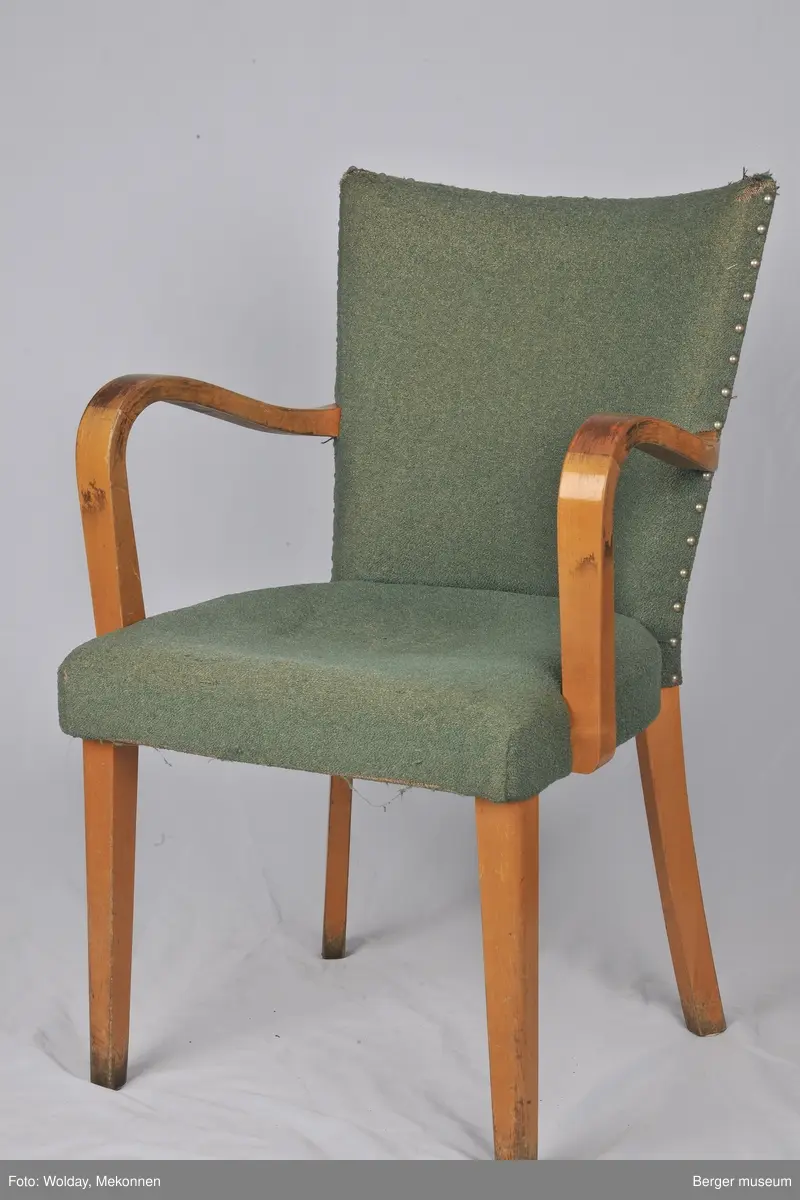 Grønt trekk med armlener. Noe slitt. Trekket er produsert på Berger fabrikker.