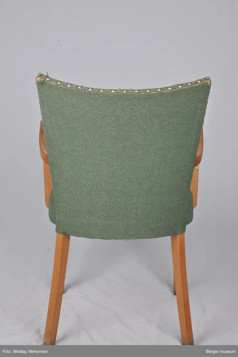 Grønt trekk med armlener. Noe slitt. Trekket er produsert på Berger fabrikker.