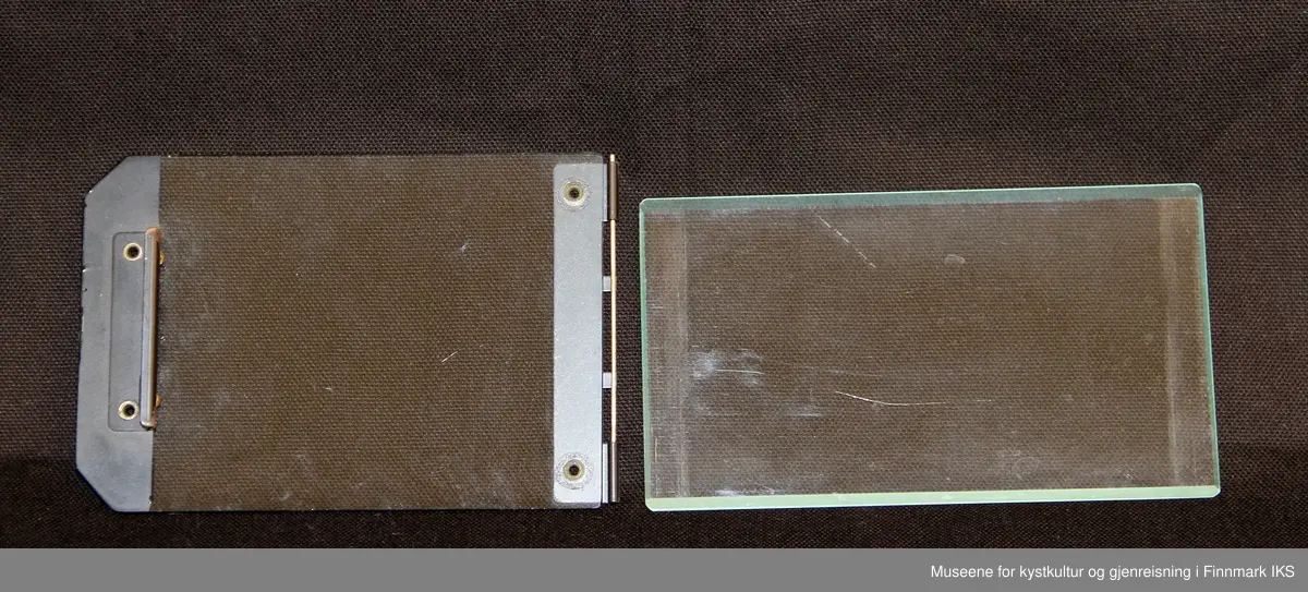 Utstyre er oppbevart i ei tre eske med 5 forskjellig rom, ei linse, flere glassplater, 2 glassplate holder, flere metall vinkler i forskjellig størrelser og flere papir border som brukes til å lage oval portretter, i forskjellige størrelser.