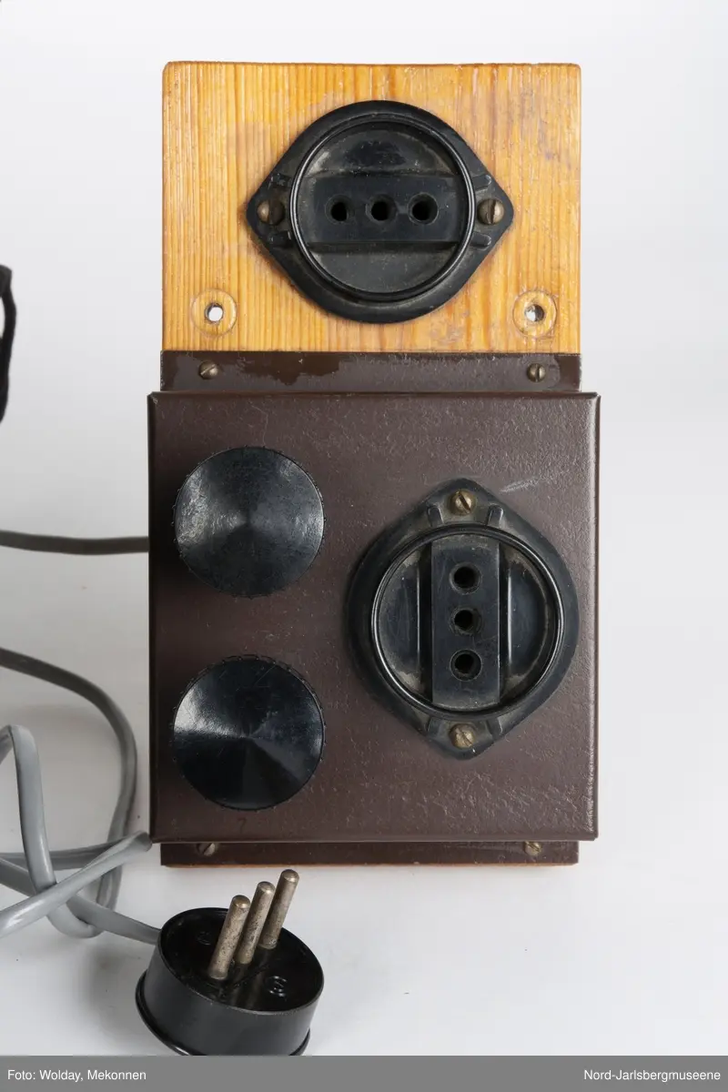 Brun metallkasse med lufterister på høyre kortside og topp. front med reguleringsknapper og hjul, rød lampe, og uttak. Elevapparater har to reguleringshjul og er montert på treplater som er koblet sammen med forsterkeren med ledning og kontakt, og til øretelefonene med ledning i kontakt. Øretelefonene er av bakelitt, metall og lær.
Sort bakelitt også på elevapparatene.


5 deler tilsammen