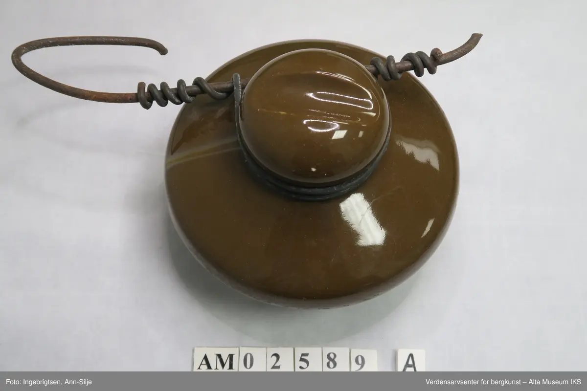Syv ulike gjenstander som alle har med elektrisitet å gjøre. A) Isolator fra kraftlinja fra Kåfjordverket til Haldde: Rund. B) Sikringsholder: Firkantet, 500 volt max. C) Isolator rund . D) Rektangulær fabrikasjonsnummerskilt fra aggregathuset. E)  3 forskjellige runde sikringer fra aggregathuset (1 stor, 2 små).