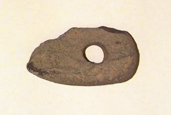 Fragment av skafthålsyxa av grönsten. Yxan skuren i sin längdriktning, mitt itu. Brottytan går diagonalt från undersidan till ovansidan. Obetydligt slipad. Omkring halva yxan är avslagen.