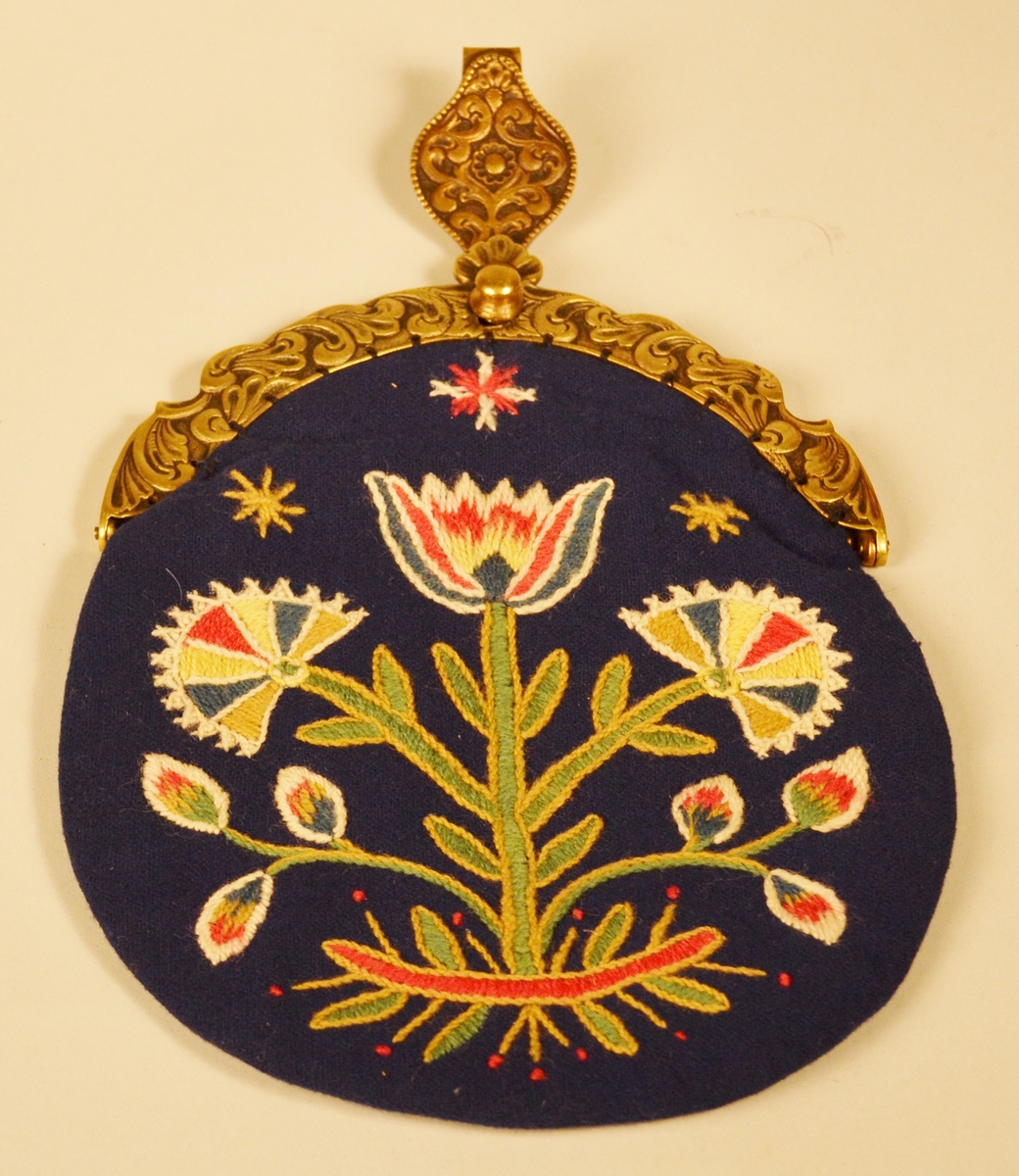 A: Bunad. Blått ullstoff, tynn klede. Har ein brodert bord 5 cm frå nedre kant. Brodert i ullgarn. Borden er 33 cm bred og går rundt same høgde. Det er en grenbord med blomster sydd i plattsøm, kontursting og franske knuter. Overdelen er eit skjørteliv. Rundt skjørtet er det brodert ein bord i kvit snorsøm, fiskebeinsting og franske knuter. Bak 3 stjerner i røde og kvite, foran på skjøtene 4 stjerner. Den broderte kvite borden fortsetter foran og opp og rundt halslinning. Foret overdel med lysgrå silke. 8 sølvringer foran i åpningen for sølvkjede. Denne bunaden har nedsydde folder frå 5 cm og opp til 8,5 cm lengde (ikkje vanleg). Splitten i skjørtet er satt saman med to trykknapper og ein hekte, og overdelen er satt saman i livet med to hekter. Skjørtet er festet til overdelen ti steder. Overdelen går i spiss ned bak.

B: Lue
Maken stoff og broderi som bunad. På pullen er det brodert eit tre med blomster. Same broderi som på overdel er brodert foran på luen. Foret med lysegrå silke. Kyse fasong. H: 17,5 cm, B:18,8 sm

C: Veske
Same stoff og broderi som bunad. Lås i messing. Same for. Låsen påsydd for hand. Låsen er merket: 
JONS KRISTIANSEN
KJOSE
NN
Veske med lås, total lengde: 28,7 cm, bredde: 16,4 cm

D: Skjorte
Kvit bomull med nuppereller. Halslinning 6 cm x 36 cm, skjorta rynket rundt halslinning. Splitt 16 cm ned midt foran. Lengde, 42 cm. Innsatt spjeld under arm 7cm x 7 cm. Vidde arm 42 cm, armlinning 6 cm x 19,5 cm. Total bredde frå arm til arm 153 cm, hvorav bolen er 52,5 cm. Innfelt skulderstykke 8,3 x 15,6 cm. Knapphull for knapper.