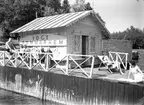 I.O.G.T:s sommarhem Lindesberg på Norrlandet, Gävle. Invigning den 30 juni 1940. Ägt av G.G.I.K. Godtemplarordens flagga är hissad. En mötesplats för ungdomar under krigsåren då Sverige var stängt. Det var fester, lekar, bad och dans på bryggan. Lindesberg låg vid viken mellan Frivy, Lervik och Kullsand. Revs när hamnen byggdes ut. Den som nu minns med glädje och tacksamhet dessa tider är nu 84-åriga Karin.