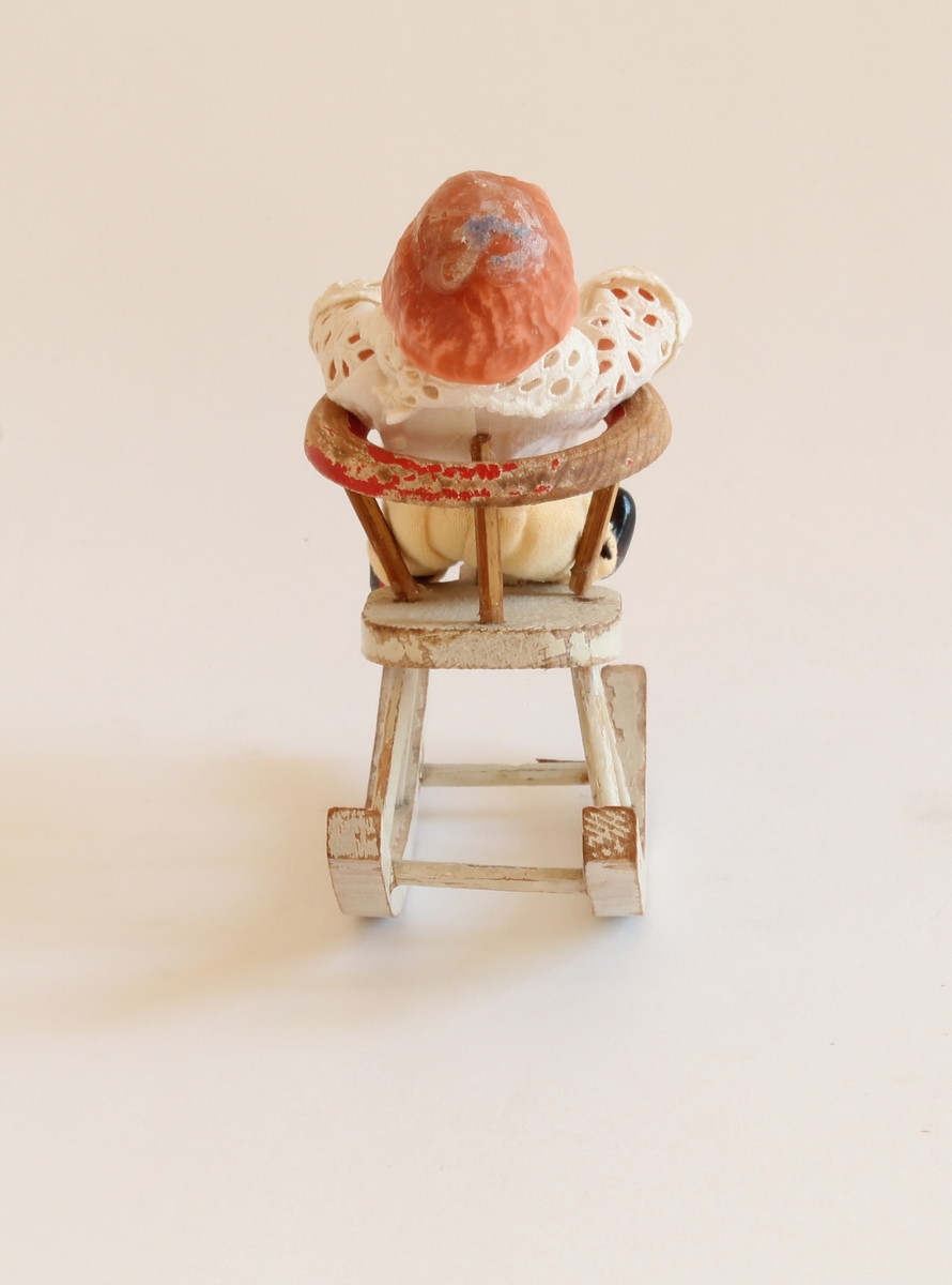 Siste eier Elisabeth Marthinsen. Gitt etter ønske fra Elisabeth til Kvinnemuseet etter hennes bortgang. Giver: datter, Heidi Graff.

Dukken er en veldig liten guttedukke som sitter på en liten gynghest. Gyngehesten er av tre. Guttedukken sitter i en stol på hesten. Stolen kan tas av fra hesten. Guttedukken er kledd i blonde skjorte og hvite nikkers med røde strømper. Hesten er hvit. Det står ikke oppført fra giver/eier om hvor Elisabeth fant denne dukken eller når hun kjøpte den.  Dukken/dukkene betydde svært mye for Elisabeth.  Se historien under.

Da Elisabeth var 13 år og bodde i Bodø, ble hun tatt med "på ferie" til Oslo. Mor, far, bror, søster og Elisabeth reiste fra hjemmet. Elisabeth tok ikke med noen leker og fikk ikke sagt farvel til noen - hverken familie eller venner. Hun fikk senere vite at " på ferie" betydde at de hadde flyttet. 

Som voksen ble det viktig for henne å få tilbake de dukkene og lekene hun hadde hatt som barn. Dette utviklet seg til å bli en hobby. Hun reiste rundt med ei venninne på markeder, antikkmesser og auksjoner. Dette koste Elisabeth seg veldig med.  

Elisabeth flyttet til Kongsvinger i 1973, siden foreldrene hennes hadde flyttet hit. Hun var først husmor. Pendlet noen år til Oslo, og arbeidet så videre noen år  i Kongsvinger.
